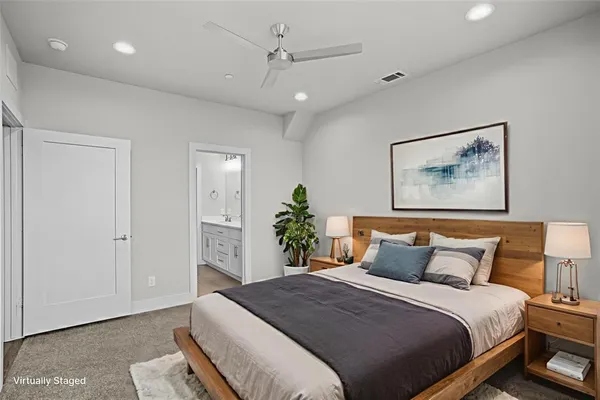 a bedroom with a large bed and a chandelier