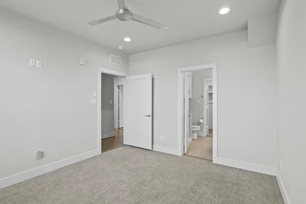an empty room with a ceiling fan and closet area