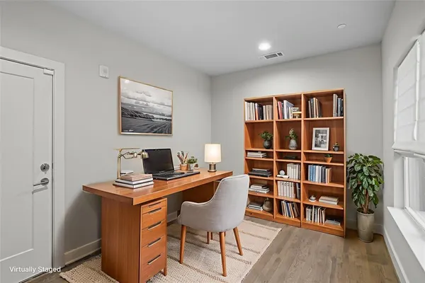 a view of a workspace with furniture and wooden floor