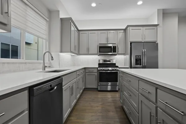 a kitchen with kitchen island granite countertop a sink stove and refrigerator