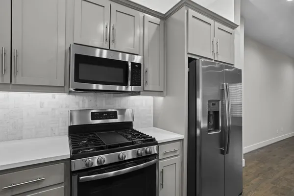 a kitchen with stainless steel appliances a refrigerator stove and microwave