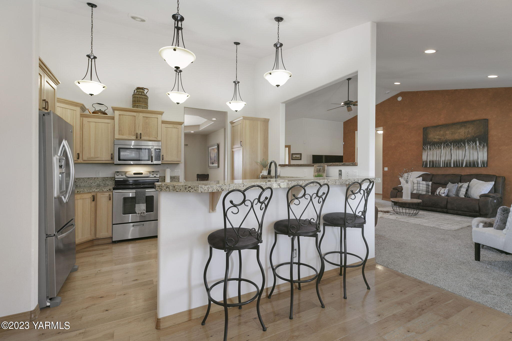 1870 Slavin Road Yakima, WA 98903 - Photo 12 of 27 a kitchen with stainless steel appliances kitchen island granite countertop a kitchen island a stove a sink a dining table and chairs
