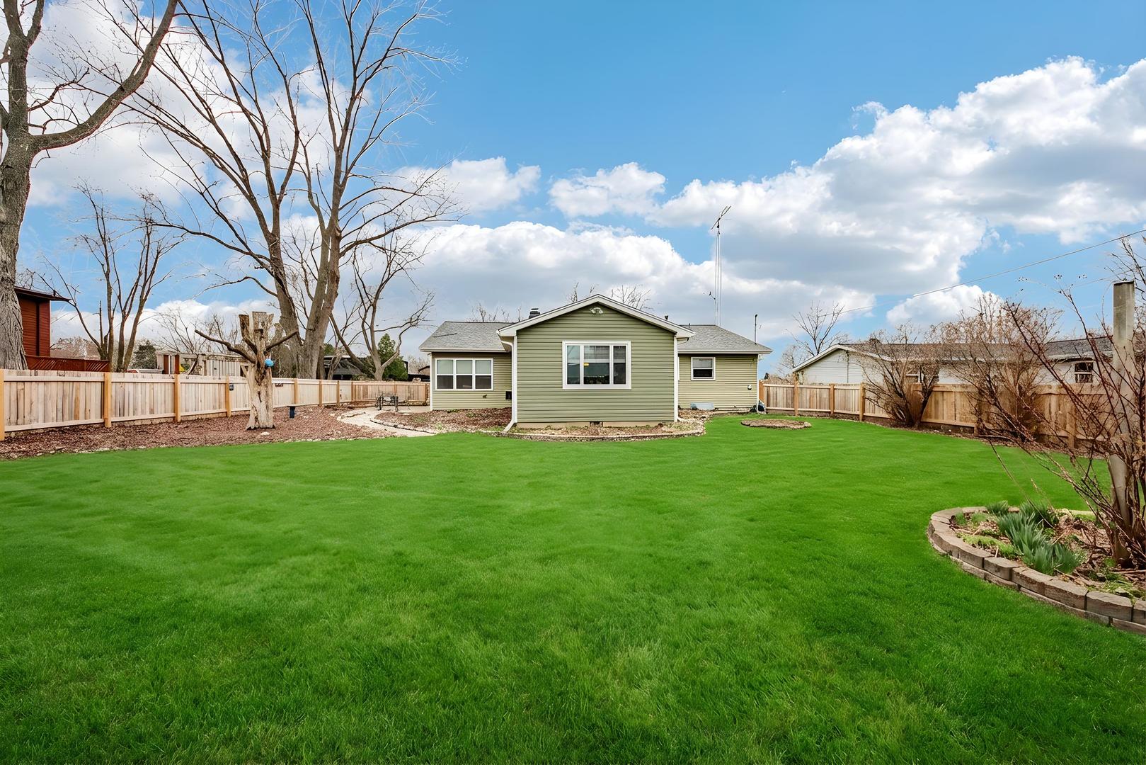 1618 Pine Trail Sycamore, IL 60178 - Photo 29 of 33 a view of a white house in front of a big yard with plants and large trees