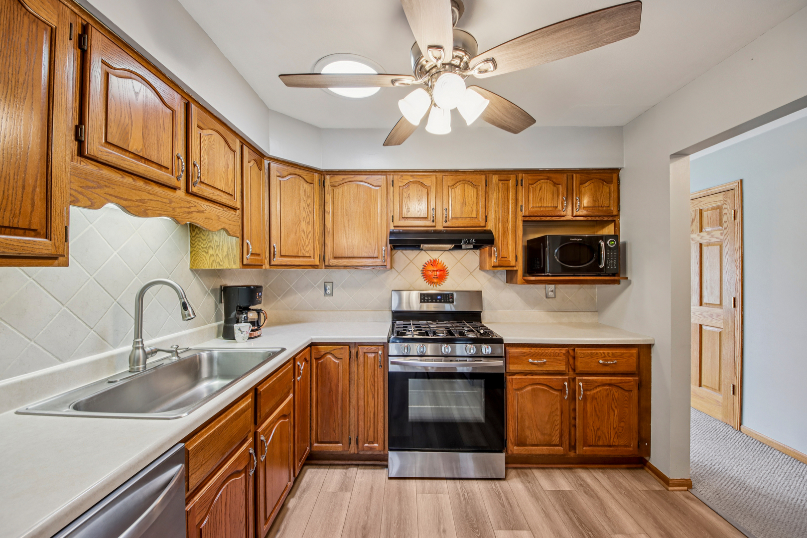 1618 Pine Trail Sycamore, IL 60178 - Photo 7 of 33 a kitchen with stainless steel appliances a stove sink microwave and cabinets