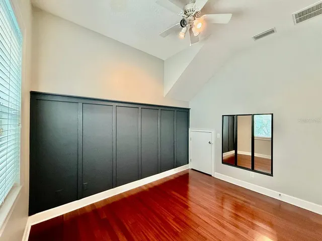 an empty room with closet and windows