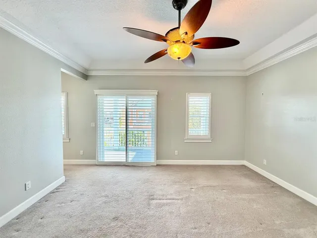 an empty room with a ceiling fan and window