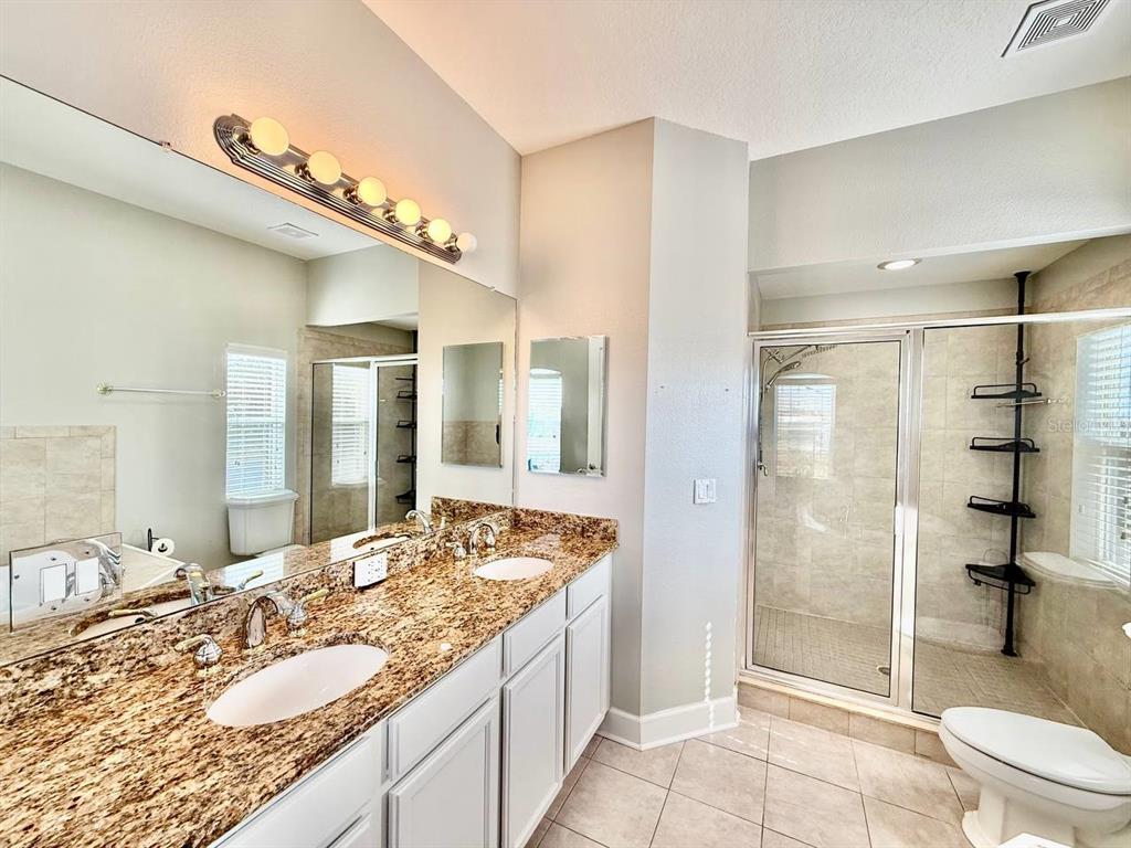 6545 Simone Shores Circle Apollo Beach, FL 33572 - Photo 21 of 46 a bathroom with a granite countertop sink mirror vanity and toilet