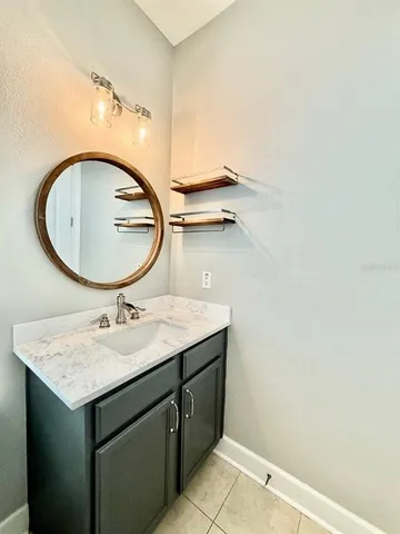 a bathroom with a granite countertop sink and a mirror