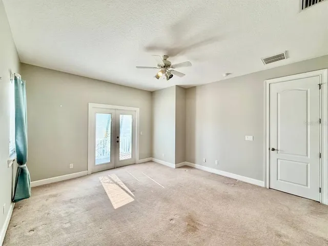 an empty room with fan and windows