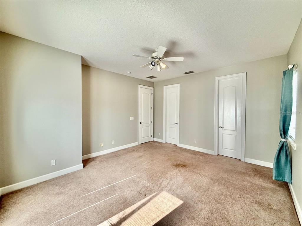 6545 Simone Shores Circle Apollo Beach, FL 33572 - Photo 34 of 46 an empty room with closet and a ceiling fan