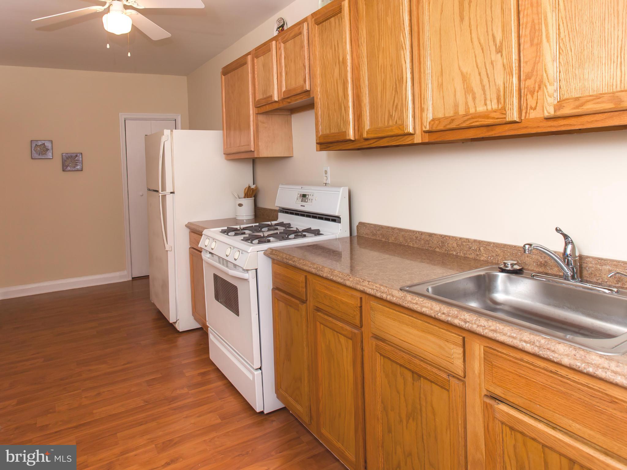 2962 Cornwall Road Dundalk, MD 21222 - Photo 1 of 28 a kitchen with stainless steel appliances granite countertop a sink a stove a refrigerator with grey cabinets