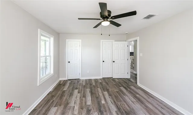 a view of a room with wooden floor and window