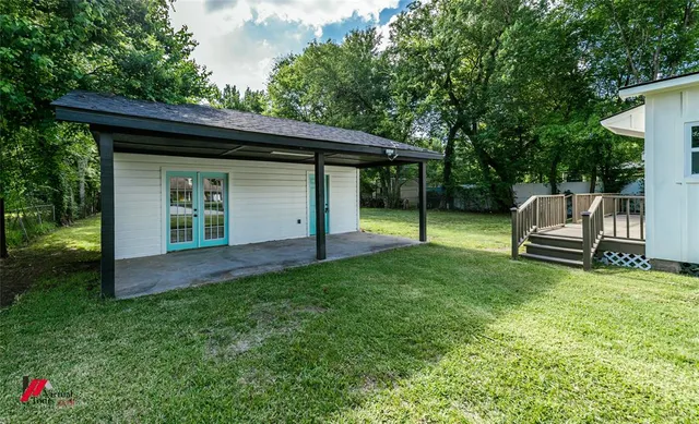 a view of backyard with wooden fence and a large tree