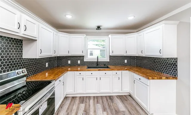 a kitchen with wooden cabinets stove and sink