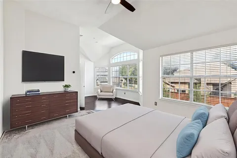 a spacious bedroom with a bed and flat screen tv