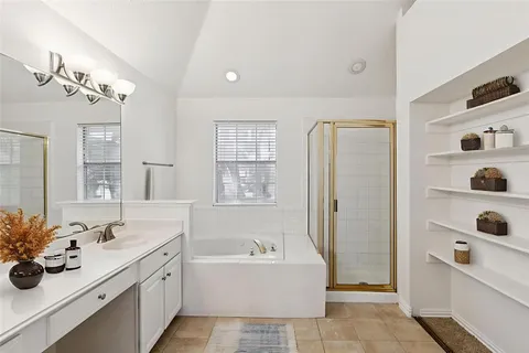 a bathroom with a tub sink and mirror
