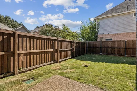 a view of backyard with wooden fence