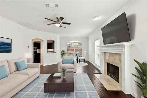 a living room with furniture a flat screen tv and a fireplace