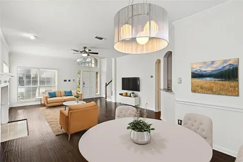 a living room with furniture chandelier and a flat screen tv