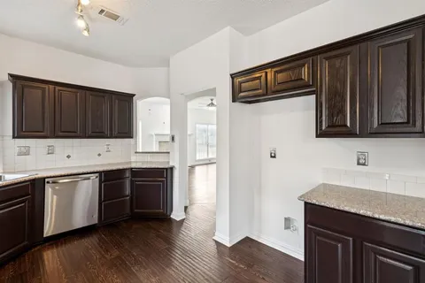 a kitchen with stainless steel appliances granite countertop wooden cabinets a refrigerator and a sink