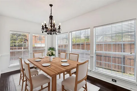 a view of a dining room with furniture wooden floor and chandelier