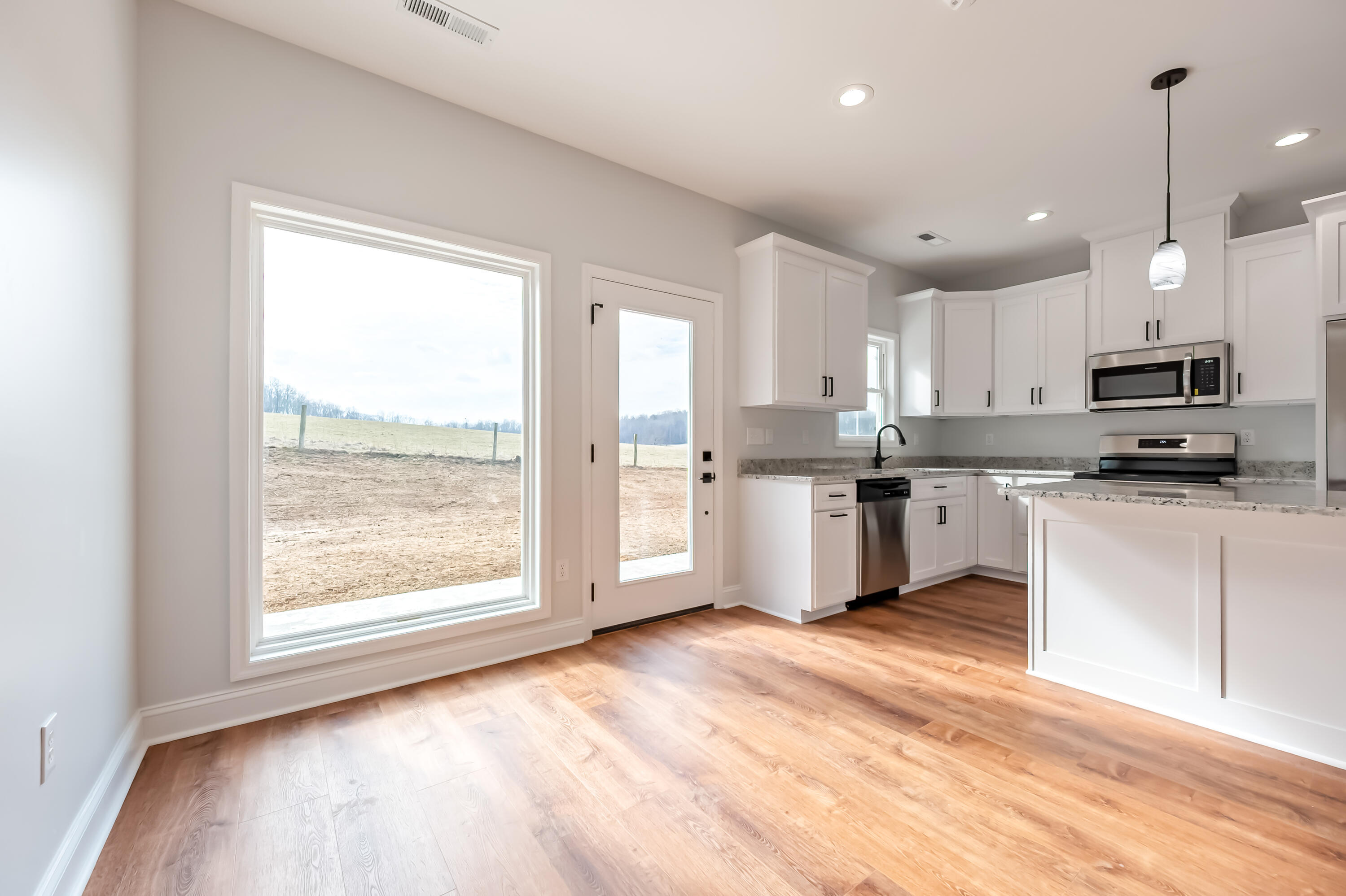 1047 Barberry Road Southeast Floyd, VA 24091 - Photo 12 of 50 a kitchen with stainless steel appliances granite countertop a stove a sink dishwasher a refrigerator and white cabinets with wooden floor