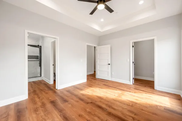 a view of an empty room and window wooden floor and closet area