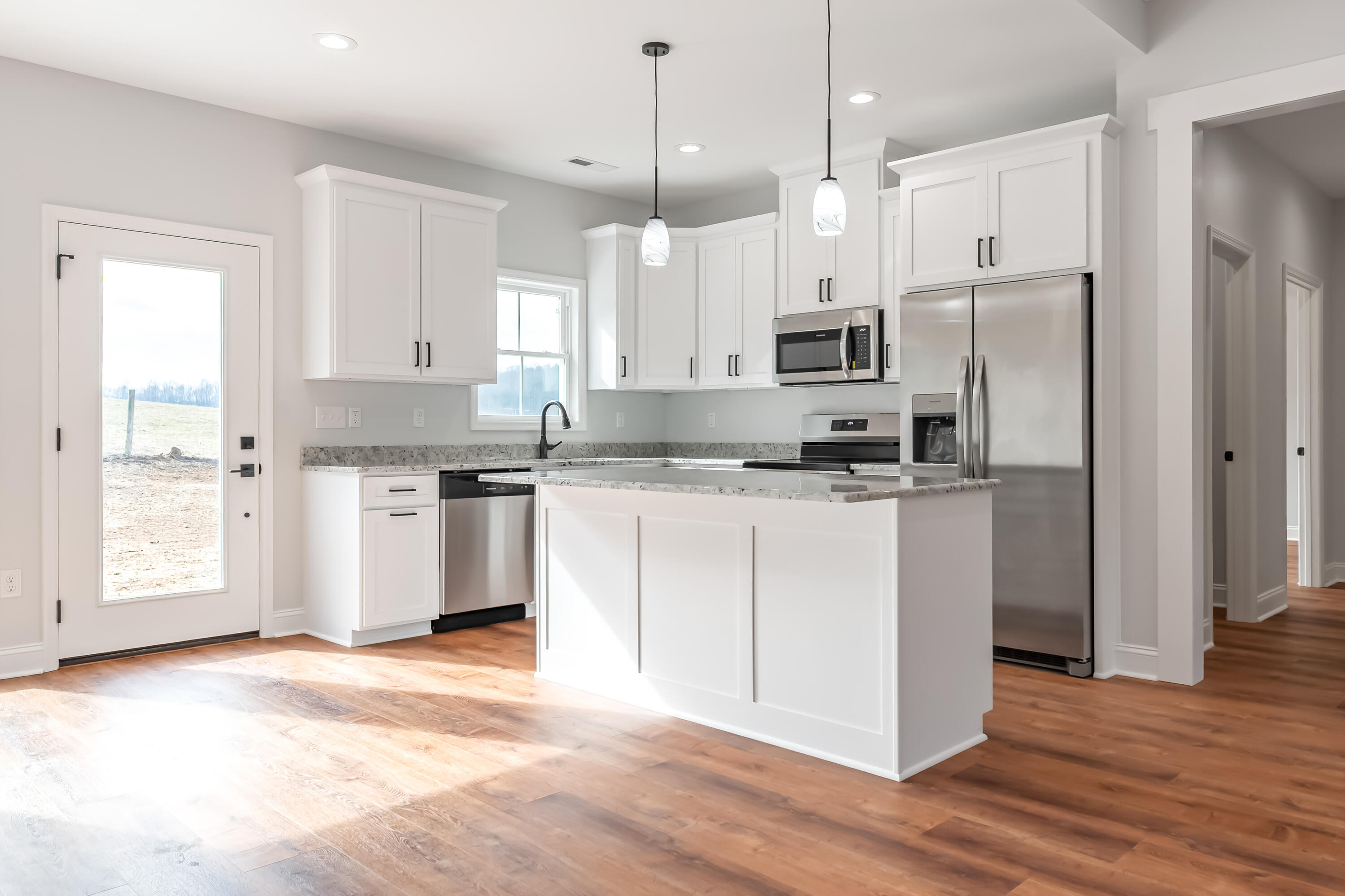1047 Barberry Road Southeast Floyd, VA 24091 - Photo 10 of 50 a kitchen with stainless steel appliances granite countertop a refrigerator a sink a stove and white cabinets with wooden floor