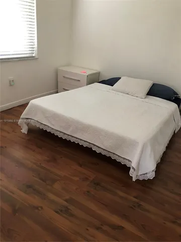 a large bed sitting in a bedroom next to a window