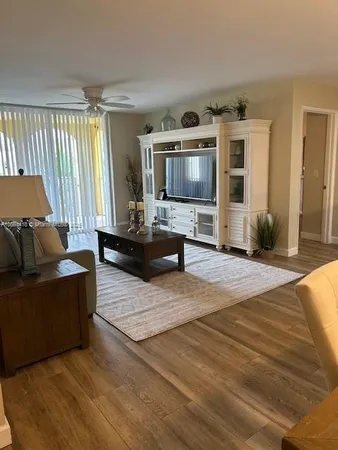 a kitchen with stainless steel appliances a dining table chairs refrigerator and microwave