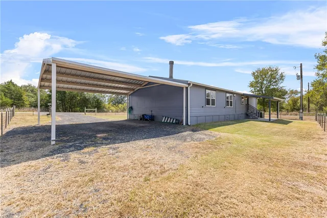 a view of a house with backyard and trees