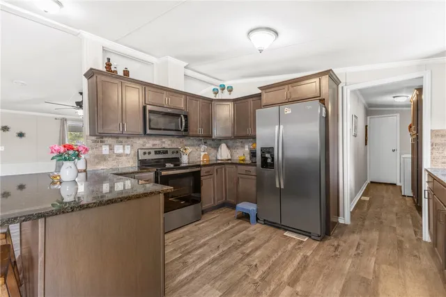 a kitchen with granite countertop a refrigerator stove and sink