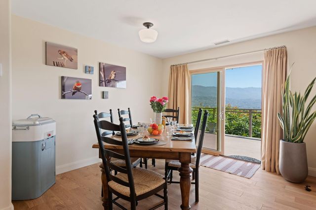 a dining room with furniture large windows and wooden floor