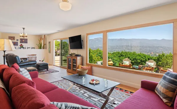 a living room with furniture a flat screen tv and a large window