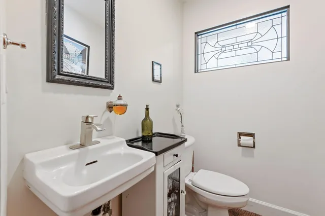 a bathroom with a toilet sink and mirror
