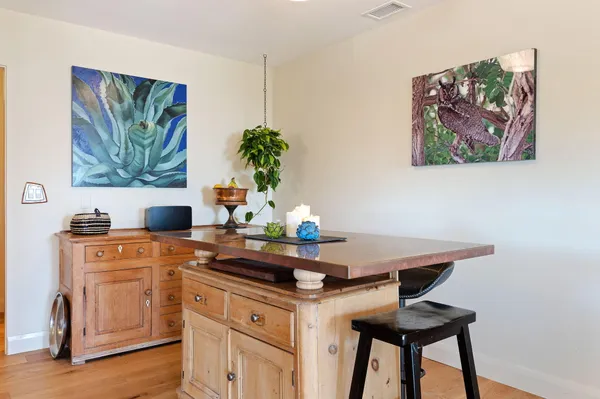 a dining room with furniture large windows and wooden floor