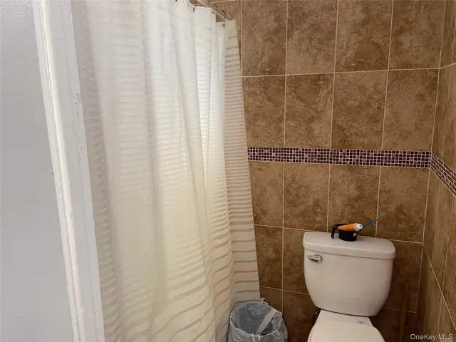 a bathroom with a toilet and a shower curtain