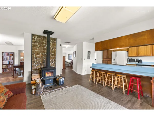 a living room with furniture a rug and kitchen area