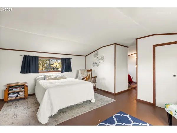 a bedroom with a bed and a large mirror