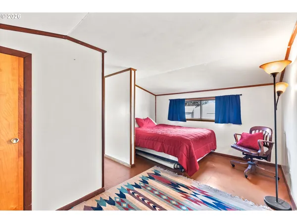 a bedroom with a bed and wooden floor