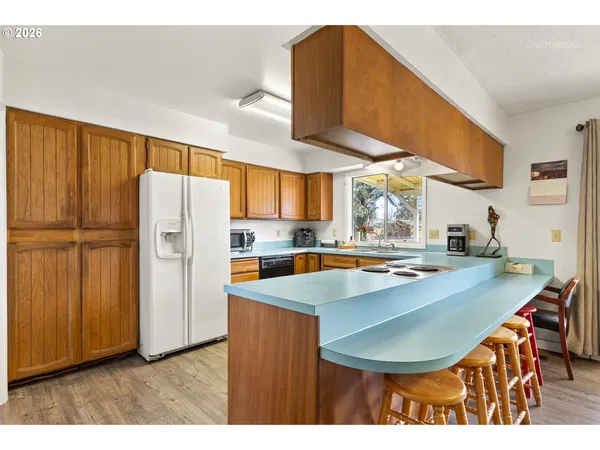 a kitchen with stainless steel appliances granite countertop a sink a refrigerator and a stove