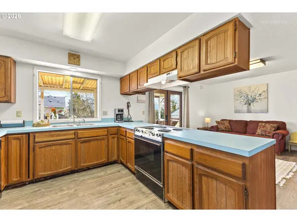 a kitchen with stainless steel appliances granite countertop a sink and dishwasher a stove with wooden cabinets