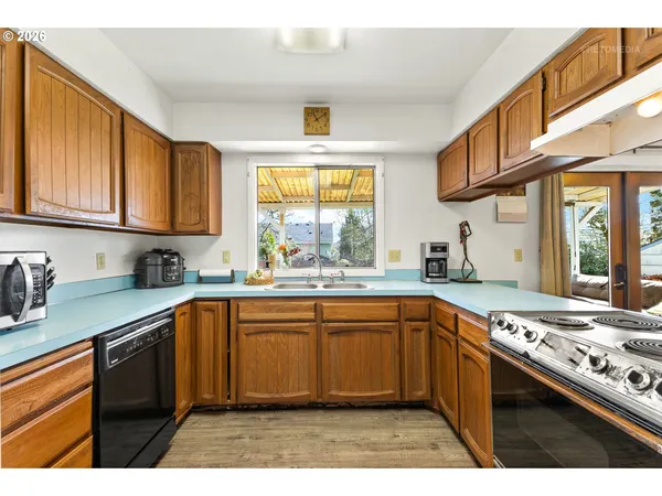a kitchen with stainless steel appliances granite countertop a sink stove cabinets and a window