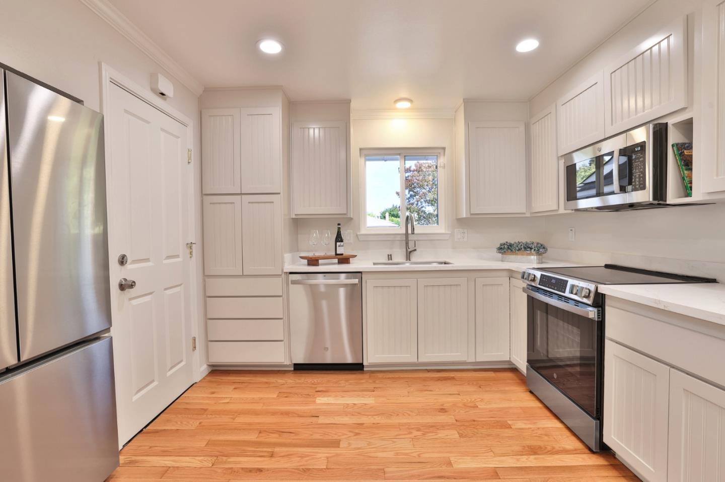 889 Ebbetts Drive Campbell, CA 95008 - Photo 11 of 33 a kitchen with white cabinets and stainless steel appliances