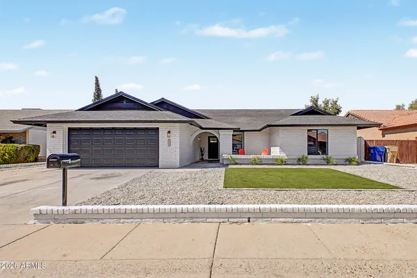 a front view of a house with a garden and plants