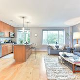 a large living room with stainless steel appliances kitchen island granite countertop a large window