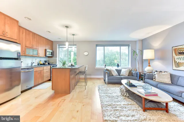 a large living room with stainless steel appliances kitchen island granite countertop a large window