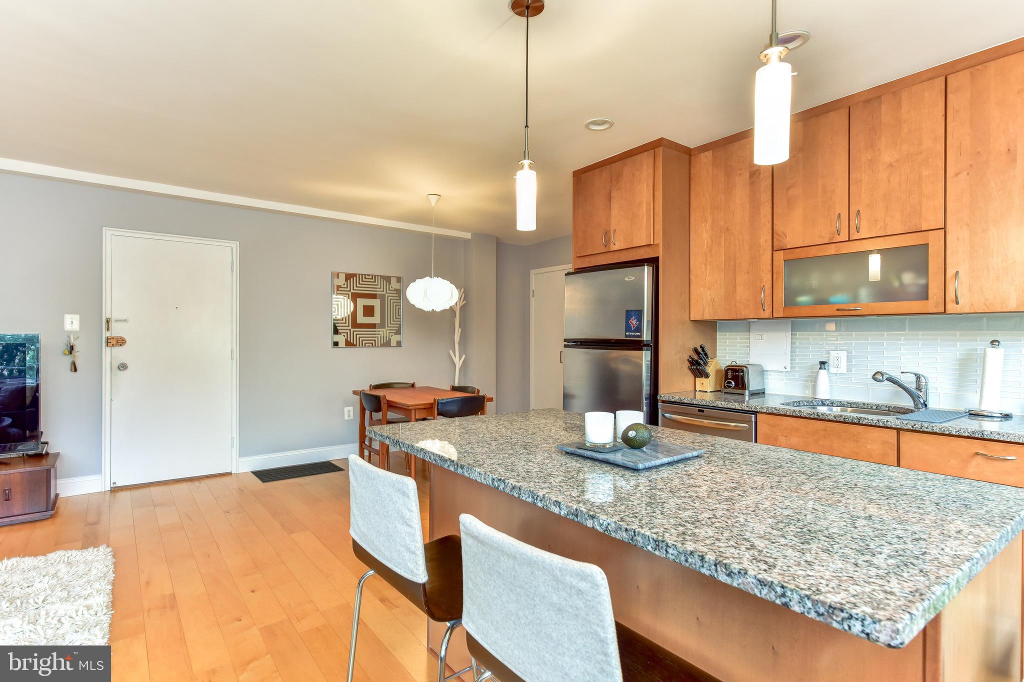 4100 W Street Northwest, Unit 510 Washington, DC 20007 - Photo 9 of 22 a kitchen with stainless steel appliances granite countertop a sink a stove and a wooden cabinets