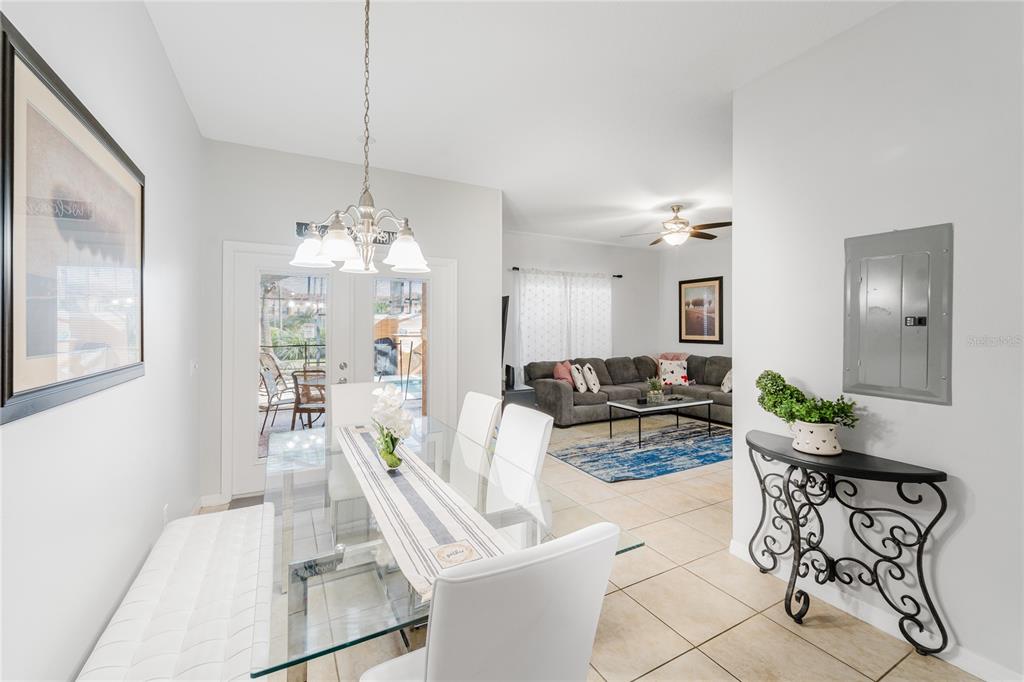 8961 Majesty Palm Road Kissimmee, FL 34747 - Photo 8 of 40 a living room with furniture and a chandelier