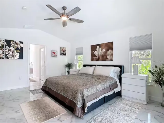 a bedroom with a large bed and a chandelier